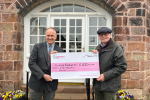 Dr Neil Hudson MP presenting a cheque to Keith Meller of the Border Rambler bus charity